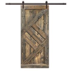 an old wooden door hanging on a metal rod with wood planks and iron bars