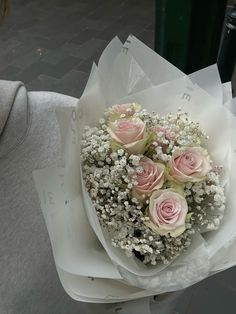 a bouquet of pink roses sitting on top of white paper