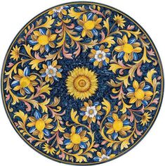 an intricately painted plate with sunflowers and leaves in blue, yellow and orange colors