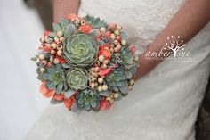 a bride holding a bridal bouquet with succulents