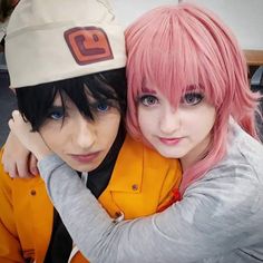 two people with pink hair are hugging each other