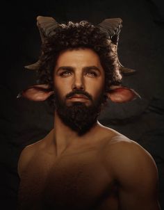 a man with long hair and horns on his head is posing for a photo in front of a dark background