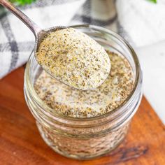 a spoon full of seasoning sitting on top of a wooden cutting board