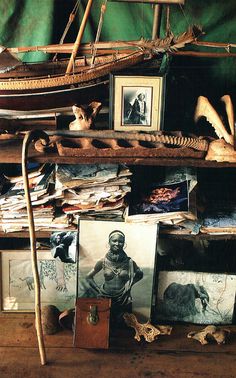 an old wooden shelf with pictures and other items on it, including a sailboat