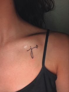 a woman with a tattoo on her shoulder and the letter y behind her back neck