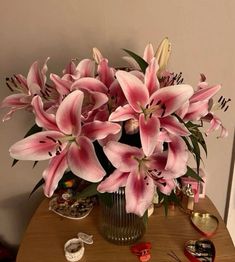 a vase filled with pink flowers sitting on top of a table next to other items