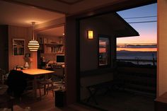 an open door leading to a living room and dining area with a view of the ocean