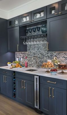 a kitchen filled with lots of cabinets and counter top space next to a wine glass rack