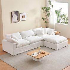 a living room with a large white sectional couch and coffee table in the center area