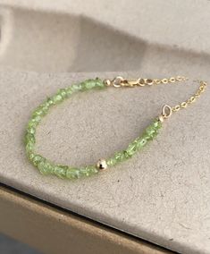 This raw peridot bracelet is available in gold filled or sterling silver.  It's layered with an off center smooth bead and finished with delicate chain and a lobster claw.  This bracelet looks great on it's own and stacks well with other bracelets. You may also like the coordinating necklace pictured in the 6th photo, link below.  A wonderful gift for an August birthday girl or a special girl on any occasion. Please select your wrist size and metal preference from the drop down menu at check out. The peridot is approx 3-6mm. You may also like to check out the coordinating necklace and more of my peridot jewelry here: https://etsy.me/2LEOuXi You may also like to check out more of my bracelets here: https://etsy.me/2KrakO6 Free first class USPS shipping within the USA. Green Gemstone Bracelet, Green Stone Bracelet, True Spring, Peridot Bracelet, August Birthday, Peridot Jewelry, Brown Bracelet, Special Girl, Delicate Chain