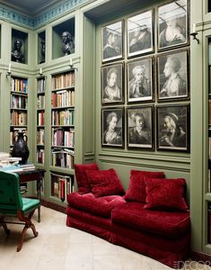 a living room filled with lots of furniture and bookshelves covered in framed pictures