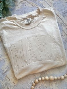 Love this tee but looking for a different name?! I got you, boo! Just message me for a custom order. Fees may apply.  Looking for the matching Mini shirt? Here's the link: https://www.etsy.com/ByMissSally/listing/1447103037/embroidered-mini-shirt-leopard-mini?utm_source=Copy&utm_medium=ListingManager&utm_campaign=Share&utm_term=so.lmsm&share_time=1679769526224 -------------------------------------------------------------------------------------------------------------------------------- Our shir White Embroidered T-shirt For College, White Relaxed Fit T-shirt With Letter Embroidery, White Cotton Top For Mother's Day, White Cotton Tops For Mother's Day, Casual T-shirt With Embroidered Text For Mother's Day, Mother's Day Crew Neck Cotton Shirt, Mother's Day Cotton Crew Neck Shirt, Cotton T-shirt With Letter Embroidery For College, White Embroidered Graphics T-shirt For College