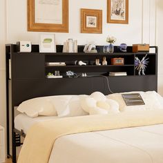 a bed with a book shelf above it in a room that has pictures on the wall