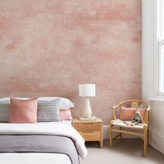 a bed room with a neatly made bed and a chair next to the window in front of it