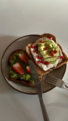 a sandwich with avocado, strawberries and whipped cream on it next to a fork