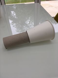 a roll of toilet paper sitting on top of a white table next to a window