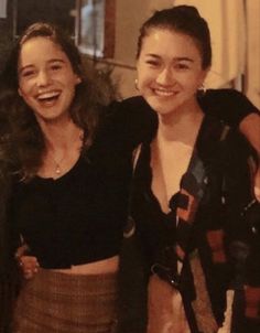 two women standing next to each other smiling