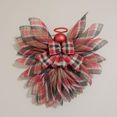 a red and white christmas decoration hanging on the wall next to a pair of scissors