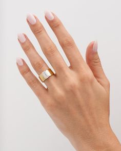 a woman's hand wearing a gold and silver ring