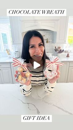 a woman is holding up some chocolates in her hands and smiling at the camera