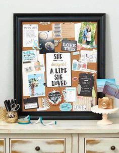 a cork board with pictures and writing on it, sitting next to other items in front of a white wall