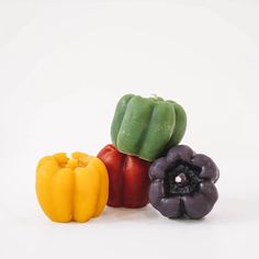 three bell peppers and one yellow pepper on a white background