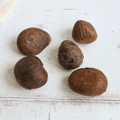 four nuts are sitting on a white surface