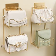 three gold and white purses are hanging on the wall next to each other,