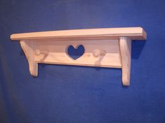 a wooden shelf with a heart cut out of it's sides on a blue background