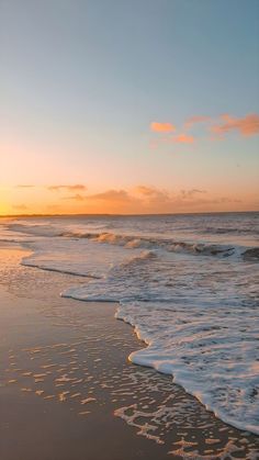 the sun is setting over the ocean waves