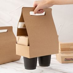 a person is holding a paper towel in a cardboard box with two boxes behind it