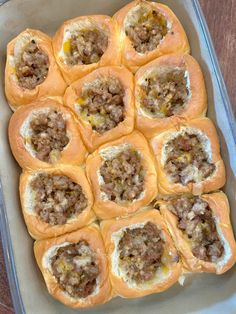 a pan filled with sausage rolls on top of a wooden table