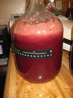 a large jug filled with liquid sitting on top of a wooden table