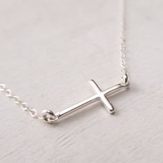 "Sterling Silver Sideways Cross Necklace Dainty and minimalist sideways cross necklace. Lightweight, perfect for everyday wear. Wear it as a choker, or choose a longer chain for a classic look. FEATURES: * dainty cross hangs in the middle of the necklace, * comes on a delicate flat cable chain, finished with a spring clasp closure. MEASUREMENTS: * sterling silver cross is 6/8\" wide and 3/8\" high (19x10 mm) * sterling silver cable chain is 1.4 mm wide * the necklace shown on a life size mannequ Everyday Minimalist Cross Pendant Necklace, Minimalist Daily Wear Cross Pendant Necklace, Minimalist Everyday Cross Necklace, Minimalist Sterling Silver Cross Necklace With Clavicle Chain, Minimalist Cross Necklace For Everyday, Silver Minimalist Cross Necklace With Clavicle Chain, Minimalist Cross Necklace With Clavicle Chain, Minimalist Cross Necklace With Delicate Chain, Simple Everyday Cross Pendant Necklace