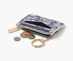 a purse with coins and a keychain on the front, sitting next to it