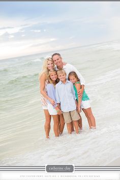 a family standing in the ocean with their arms around each other