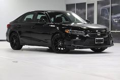 a black car is parked in a showroom