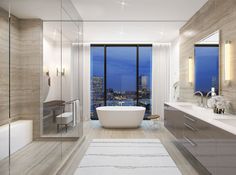 a bathroom with a tub, sink and large window overlooking the city at night time