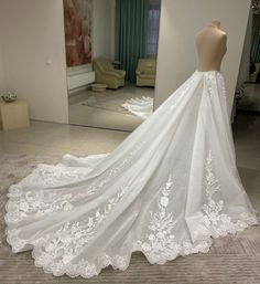 a wedding dress on display in front of a mirror