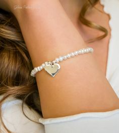 Fall in love all over again with this glimmering silver heart and pearl bracelet....................... White/ Ivory freshwater pearls are AA quality and measure about 2mm Shiny sterling heart measures about 13mm Chain is dainty 925 sterling silver Bracelet is adjustable (choose your size) Bracelet closes with a sterling silver spring clasp This is a handmade item and made for you after the order is placed PACKAGINGAll Jewelry is carefully packaged for a safe arrival and is secured in a jewelry Elegant Heart-shaped Pearl Beaded Bracelets, Wedding Heart-shaped Pearl Bracelet, Adjustable Heart-shaped Pearl Bracelet, Elegant Heart-shaped Pearl Bracelet With Charm, Elegant Heart-shaped Pearl Charm Bracelet, Silver Spring, Sterling Silver Bracelet, Sterling Silver Heart, Heart Bracelet