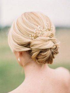 an instagram photo of a blonde woman with her hair in a low bun and pearls