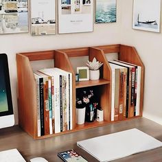 a computer desk with books and pictures on the wall