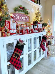 a christmas display with stockings and other holiday decorations on top of the shelves in front of them