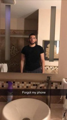 a man standing in front of a bathroom mirror with the caption forgot my phone