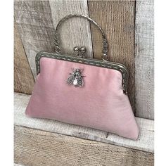 Stunning, handmade, blush pink velvet purse bag with bee detail. The lining is made with a beautiful cotton fabric. Use it as a classic clutch or attach the shoulder strap to wear over your shoulder or as a crossbody. - Silver colour Chain strap (detachable) - Silver colour Metal Top handle (not detachable) - H:19cm x W:29cm x D:4cm approximately - Metal clasp: H:6.5cm x W:20cm - Top handle: H:8.5cm The pattern of the lining inside of the bag may vary. But don't worry, I always make sure the lin Feminine Pink Clutch Evening Bag, Feminine Pink Pouch Evening Bag, Vintage Pink Pouch Clutch, Elegant Pink Pouch Coin Purse, Elegant Pink Clutch Coin Purse, Vintage Pink Clutch For Formal Occasions, Handmade Pink Evening Bag For Formal Occasions, Elegant Blush Pouch Bag, Elegant Pink Coin Purse For Formal Occasions