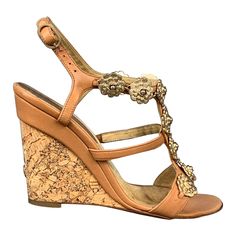 CHANEL "Camelia" sandals comes in a tan leather with gold tone floral metal embellishments featuring a t-strap, logo detail, and a cork wedge. Made in Italy.Very Good Pre-Owned Condition. Marked: EU 36.5 Measurements: Heel: 4 inches Reference: 109365 Category: Sandals More Details Brand: CHANEL Size: 6.5 Color: Tan Color 2: Gold Fabric: Leather Material: Cork Style: Wedge Age Group: Adult Gender: Female Dad Sandals, Metal Embellishments, Chanel Boutique, Tan Sandals, Cork Wedges Sandals, Pink Chanel, Black Espadrilles, Pink Sandals, Ankle Strap Pumps