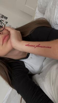 a woman laying on top of a bed wearing glasses