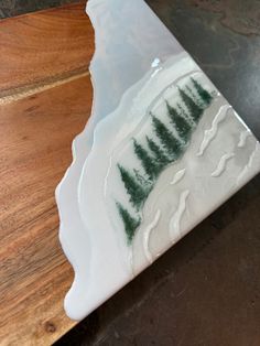 a white and green plate sitting on top of a wooden table