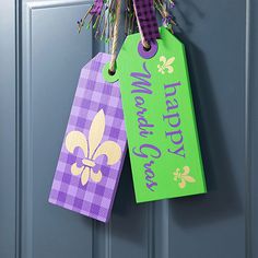 two purple and green tags hanging from a door