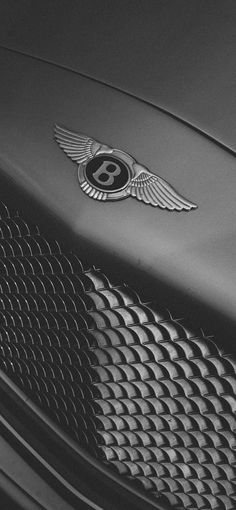 the bentley logo is on the front of a black sports car with chrome grilles